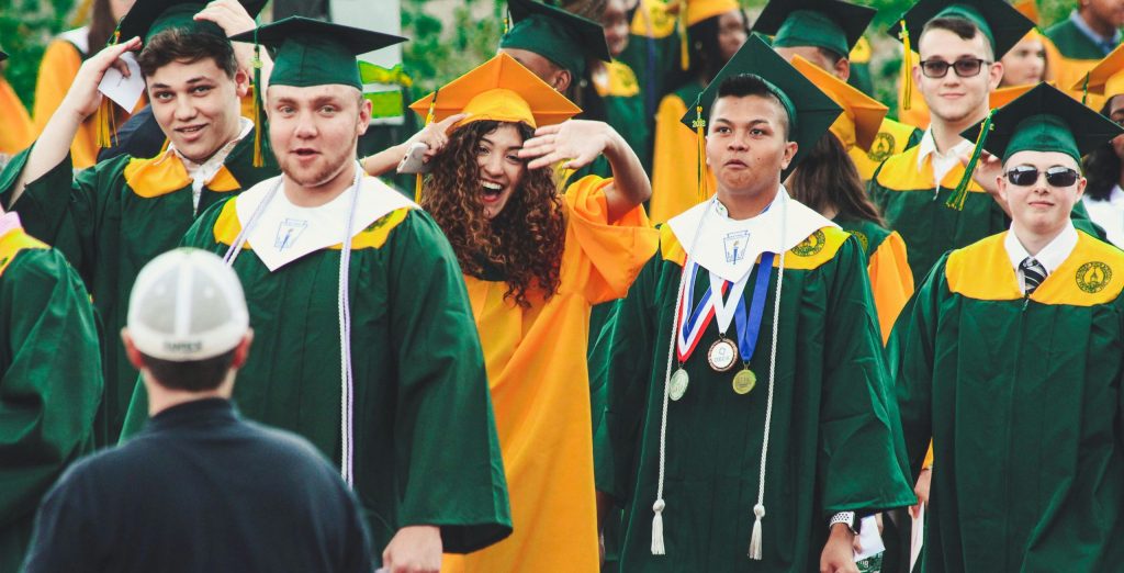 Graduates celebrate with smiles and excitement at an outdoor ceremony in Hamden, CT.