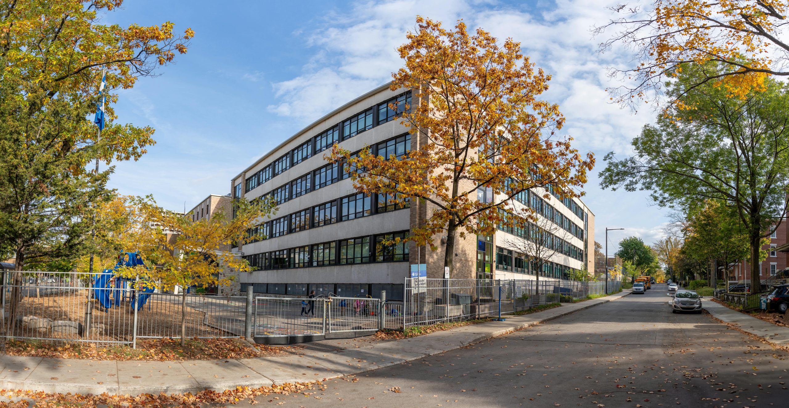 A school building in Québec city surrounded by colorful autumn trees.