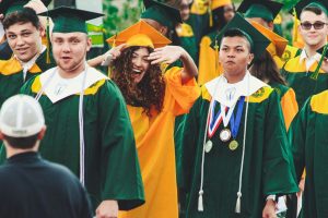 Graduates celebrate with smiles and excitement at an outdoor ceremony in Hamden, CT.